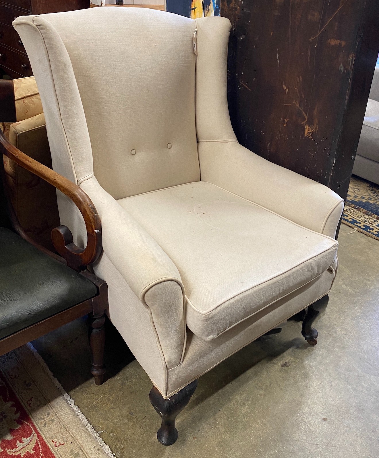 An early 20th century wing armchair, upholstered in linen, width 76cm, depth 78cm, height 102cm